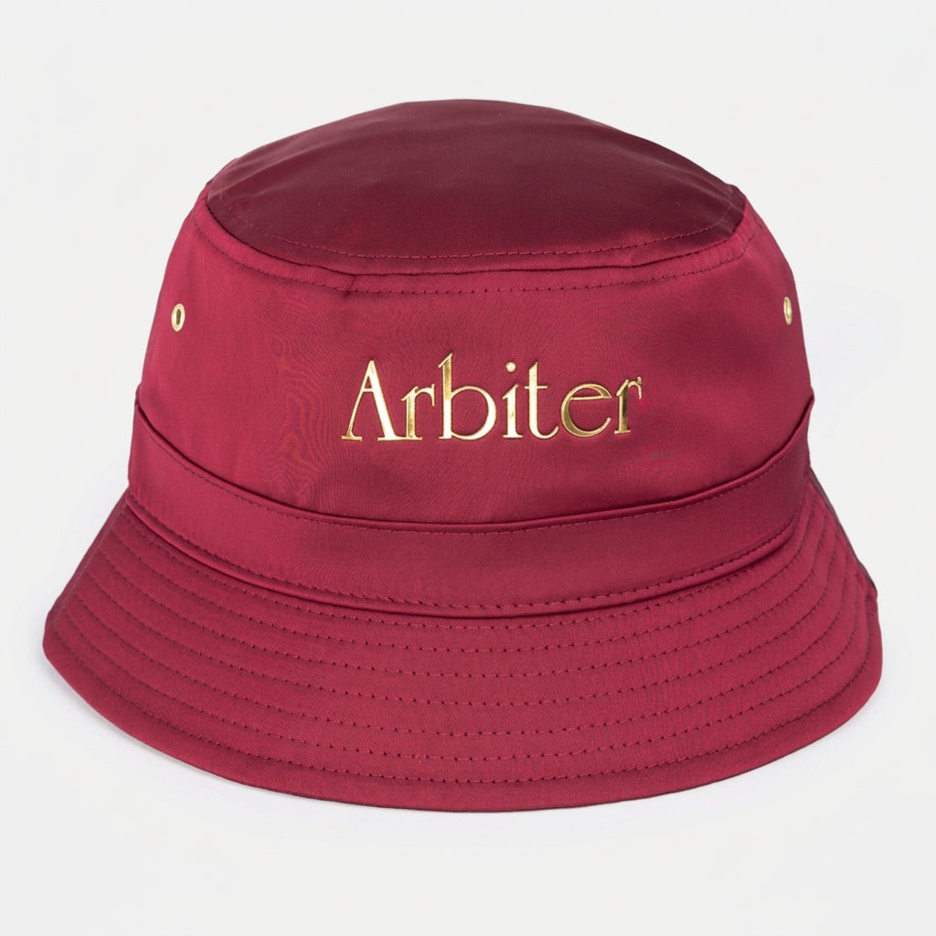 Unisex burgundy satin bucket hat by Arbiter, featuring a smooth, shiny fabric and a classic wide-brim style.