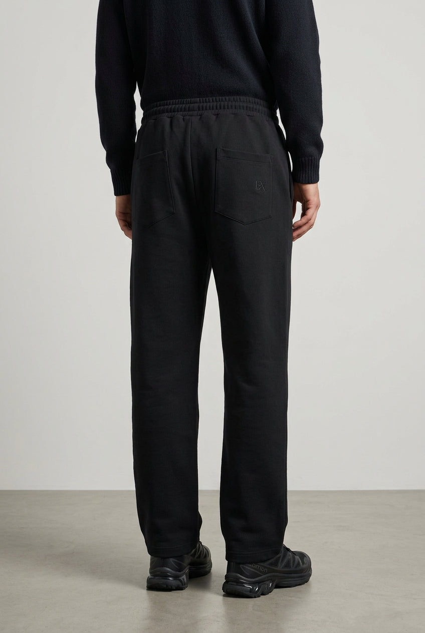 Black BA6 men's track pants with a relaxed fit and elastic waistband, shown on a neutral background.