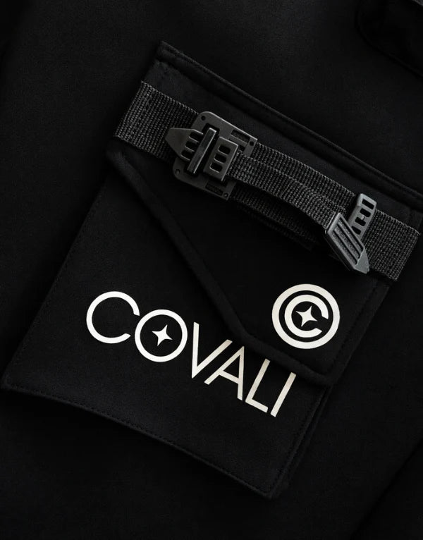 Black Covali Aprega men's track pants with a relaxed fit and elastic waistband, shown on a model.